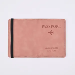 Close-up of pink PU leather passport cover detail with elastic band and travel branding.