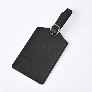 Detailed shot of black PU leather luggage tag featuring debossed adventure quote and buckle.