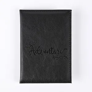 Close-up view of black PU leather passport holder with debossed travel quote detail.