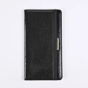 Detail view of black glitter PU leather passport cover with elastic band and metal decoration.