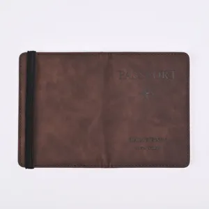 Brown PU leather passport holder detail, featuring elastic strap and debossed travel text.