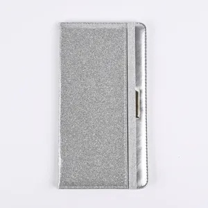 Detail view of silver glitter PU leather passport cover with elastic strap and metal accent.