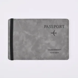Close-up detail of grey PU leather passport holder cover with black elastic band and print.