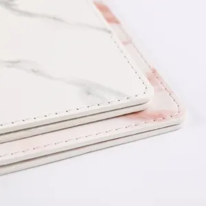 Close-up detail of marble pattern passport cover, showing neat edge stitching and smooth texture.