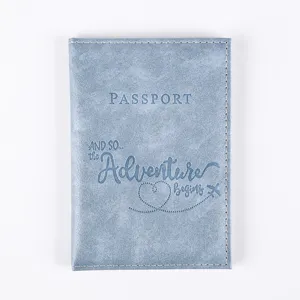 Detailed view of blue PU leather passport cover with adventure travel quote embossing.