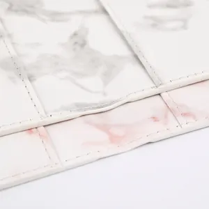 Marble passport cover detail featuring fine oil edges, precise stitching and leather texture.