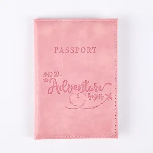 Pink PU leather passport cover with cute travel quote debossed design for travel and card storage.