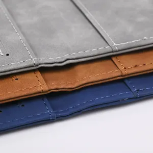 Close-up detail of PU leather passport cover organizer with neat stitching and texture.