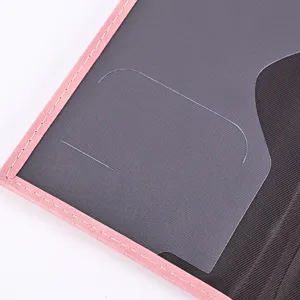 Detailed view of PU leather passport holder featuring pink edge stitching and transparent card slot.