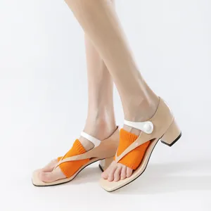 Detailed shot of square-toe mid-block heel sandals paired with vibrant orange knit toe socks.