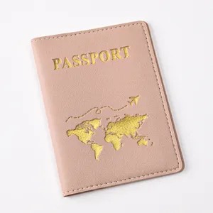 Close-up of pink PU leather passport cover with gold world map design and clear stitching.