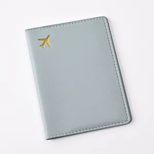 Detailed view of grey PU leather passport holder featuring gold foil airplane pattern.