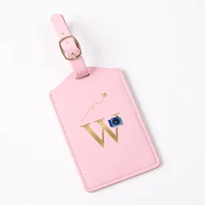 Pink leather luggage tag with gold letter W and camera motif for travel bags and suitcases.