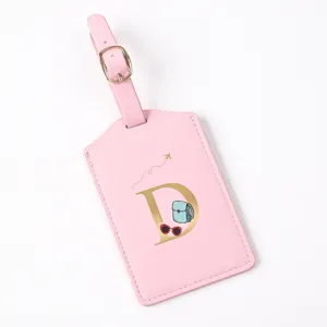 Pink leather luggage tag with gold letter D design, travel suitcase identifier label and decoration.