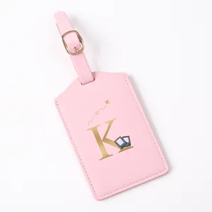 Pink leather luggage tag with gold letter K and cute airplane travel design for suitcases.
