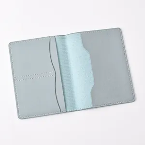 Detail view of a light blue PU leather passport cover featuring multiple card slots inside.