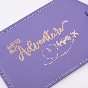 Purple PU leather luggage tag detail featuring gold foil adventure begins text and plane.