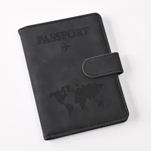 Close-up of black PU leather passport holder with magnetic snap, map and passport emboss.