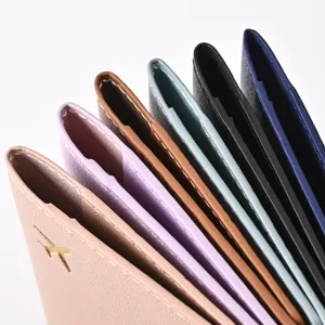 Close-up detail view of multi-color PU leather passport covers featuring neat stitching and gold foil.