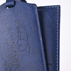 Dark blue PU leather passport holder luggage tag detail view, textured travel set close-up.