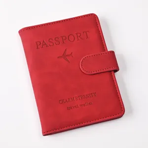 Detailed view of red PU leather passport holder with magnetic buckle and airplane embossed logo.