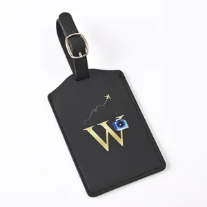 Black PU leather luggage tag detail, featuring gold letter W, buckle strap and camera icon.