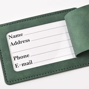 Close-up detail view of a dark green PU leather luggage tag with clear ID card slot stitching.