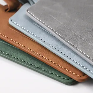 Close-up detail shot of multi-color PU leather passport holders and luggage tags with fine stitching.