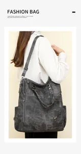 Detail view of the dark grey soft leather backpack showing shoulder strap and multi-pocket.