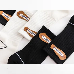 Detailansicht sportlicher Modesocken mit markantem Lederetikett und blauen Ziernähten.