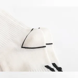 Weißer Baumwollstrick Socke Detailaufnahme mit geripptem Bündchen und schwarzem Muster.