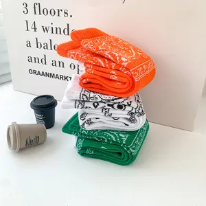 Trendy streetwear paisley bandana printed long socks in vibrant orange, white and green colors.