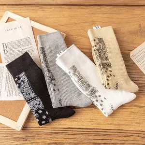 Close-up detail of stylish mid-calf cotton socks featuring classic paisley bandana print in assorted colors.