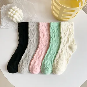 Detailed shot of cute bow embossed mid-calf cotton socks in multiple solid colors, soft ruffles.