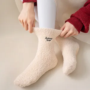 Detail view of cozy fuzzy winter slouch socks featuring cute letter embroidery and anti-slip soles.