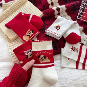 Detailed shot of festive red and white socks with cute puppy patterns and cozy knitted design.