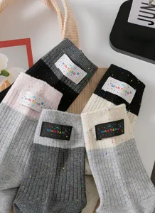 Detailansicht mehrfarbiger Slouch-Socken mit Stoffetikett und weichem Garn für Alltag.