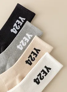 Close-up detail of ribbed long tube casual socks featuring stylish knitted letter patterns.