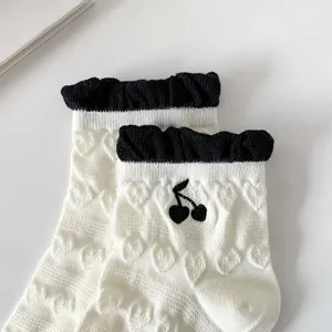 Simpatici calzini bianchi in cotone con polsini volant neri e ricamo di ciliegie per donna.