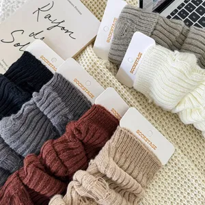 Gedetailleerde close-up van gezellige gebreide beenwarmers in effen kleuren met opvallend design.