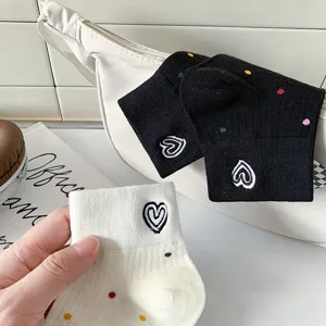 Vista dettagliata di calzini corti casual da donna con ricamo a cuore e pois colorati.