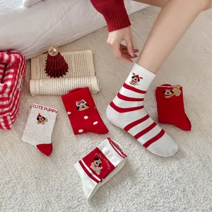 Detail view of festive red and white cotton mid-calf socks with cute cartoon dog embroidery.