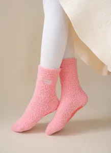 Close-up detail of plush pink winter cozy mid-tube socks with cute embroidery and anti-slip sole.