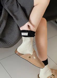 Koreanische Fleckengarn-Mittelsocken mit schwarzem Rippbündchen und Stoffetikett für den Alltag.