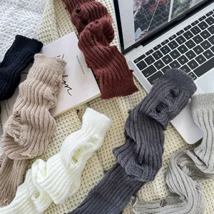 Detail van grof gebreide beenwarmers, zachte ribtextuur, trendy winterse grunge stijl voor outfits.