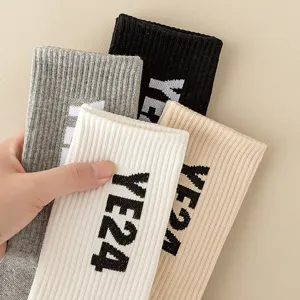 Ribbed knit long tube socks detail showcasing multi-color variety and stylish letter pattern.