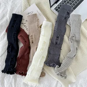 Detailopname van trendy JK stijl distressed gebreide beenwarmers in gezellige kleuren.