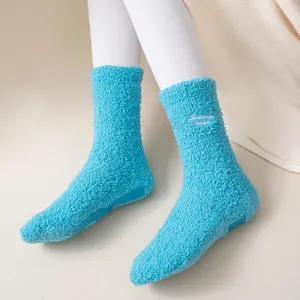 Detail view of plush fuzzy blue winter mid-tube warm socks with cute embroidery design.
