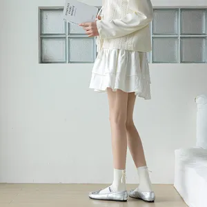 White mid-tube socks detail featuring a cute back bow, styled in a clean indoor setting.