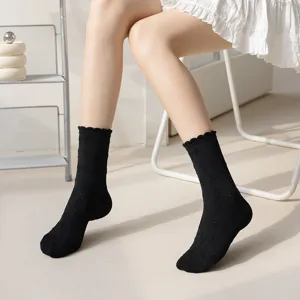 Black mid-calf socks for women featuring cute bow patterns and ruffled lace trim.